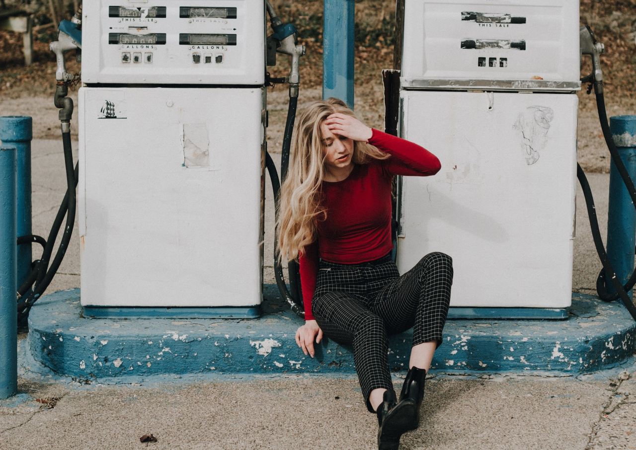 woman sits between two white gas pumps