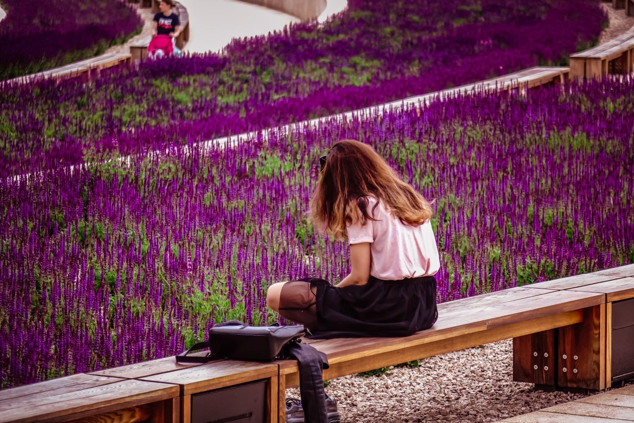 woman sitting on brown wooden bench