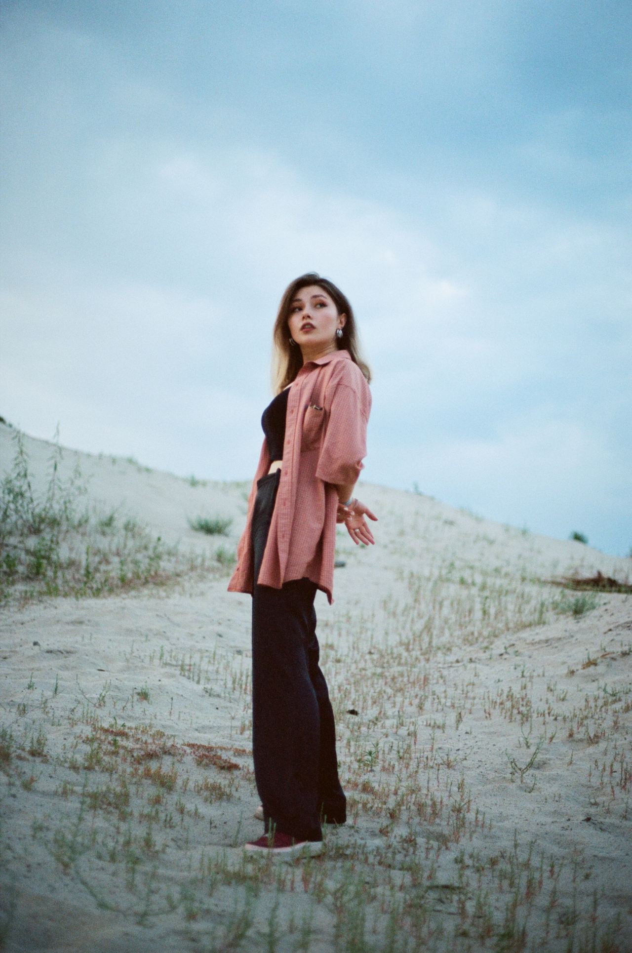 woman in pink scarf standing on brown field during daytime