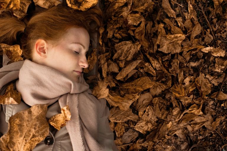 woman lying on leaves