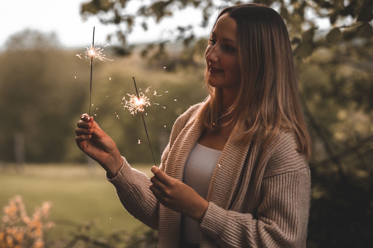 woman in white knit sweater holding white dandelion flower during daytime