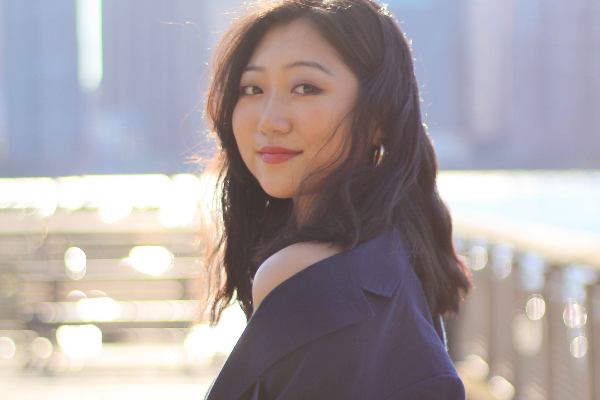 woman in black blazer standing on sidewalk during daytime