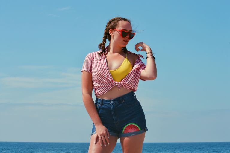 woman wearing red top and blue shorts