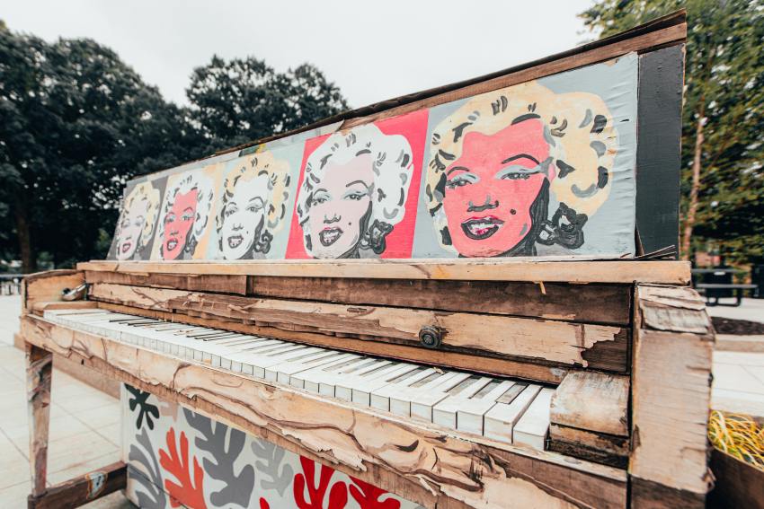 Red and white graffiti on brown wooden fence