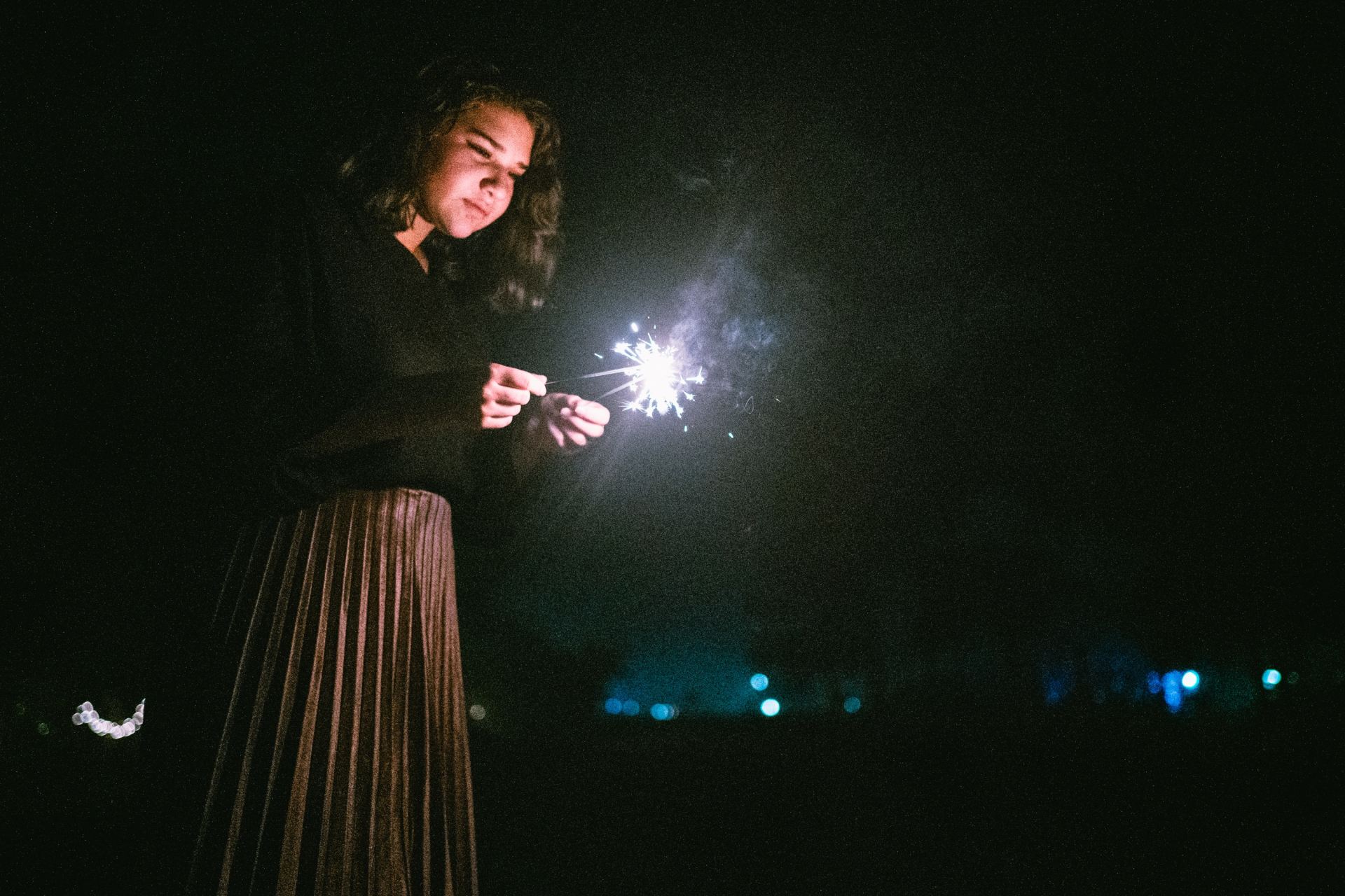 standing woman holding two sparklers