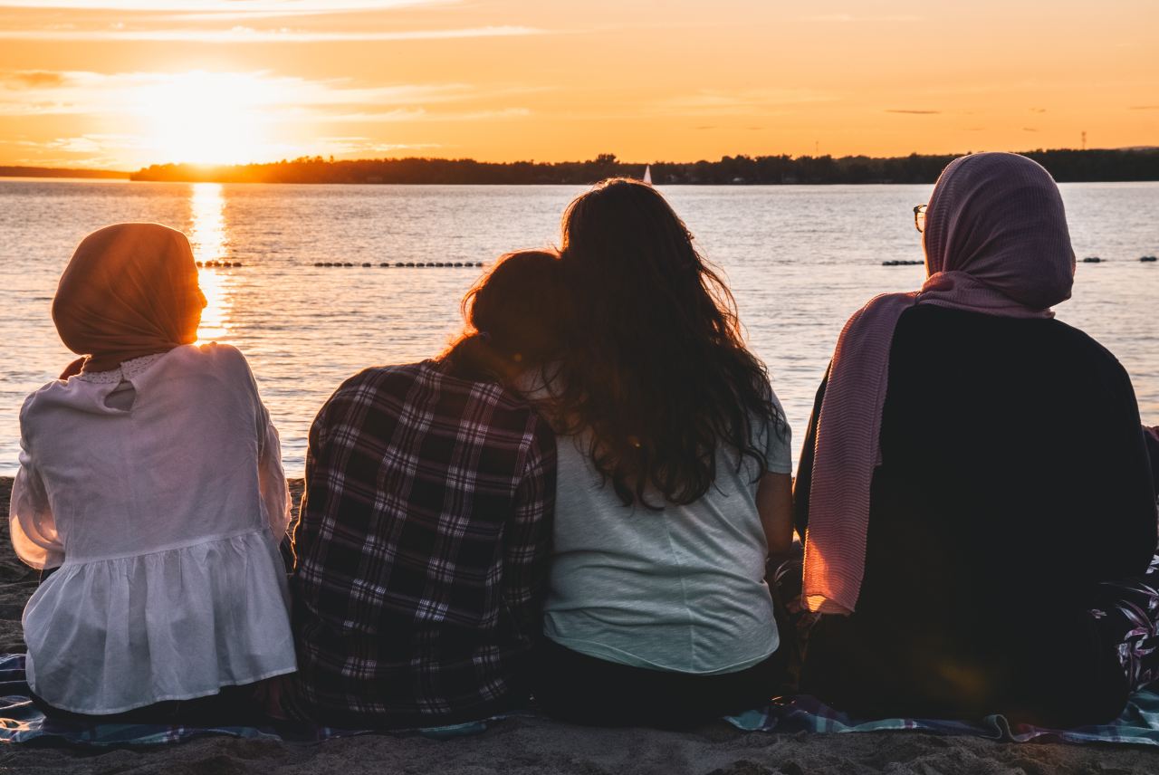 people sitting in front of body of water during daytime