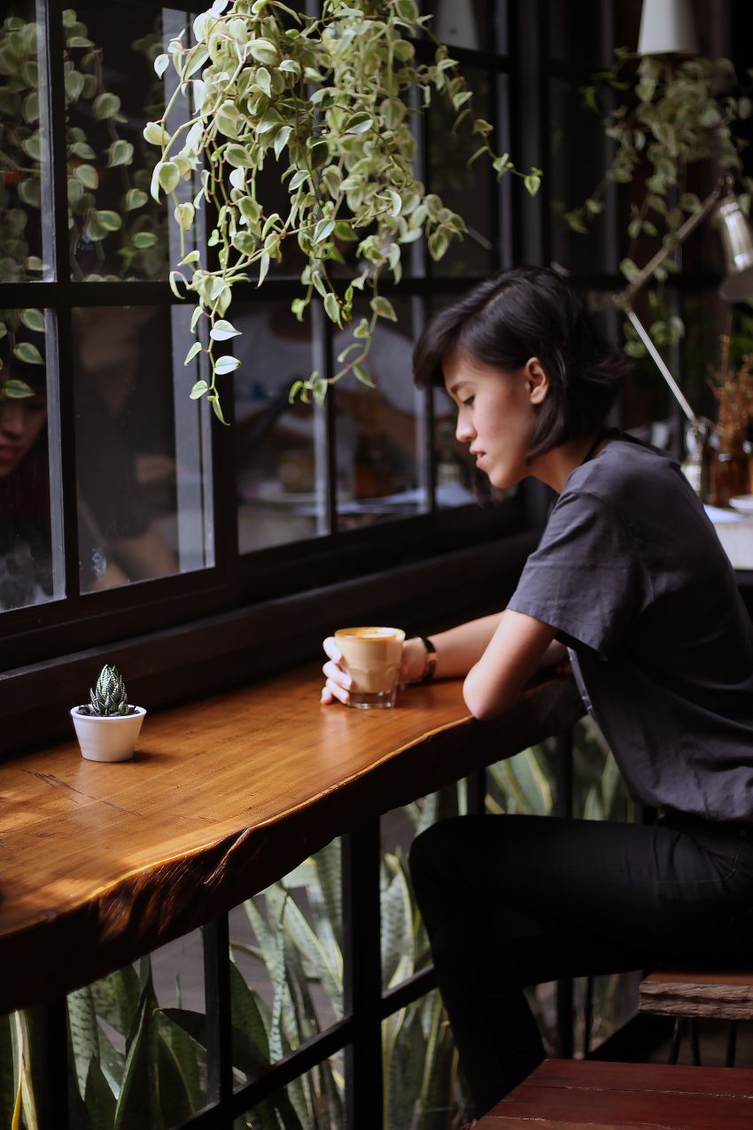 woman sitting on brown wooden chair