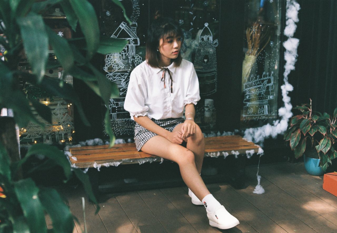 woman sitting on brown wooden bench