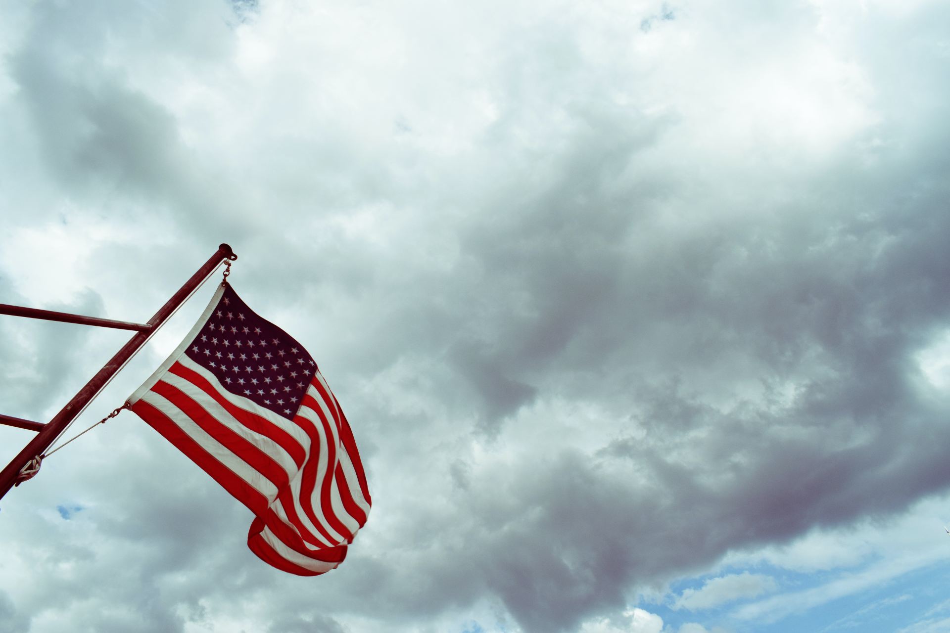 USA flag under white clouds