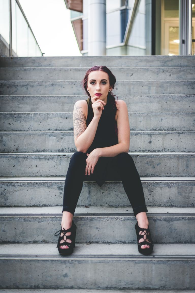 woman in black sleeveless top and black pants sitting on stair