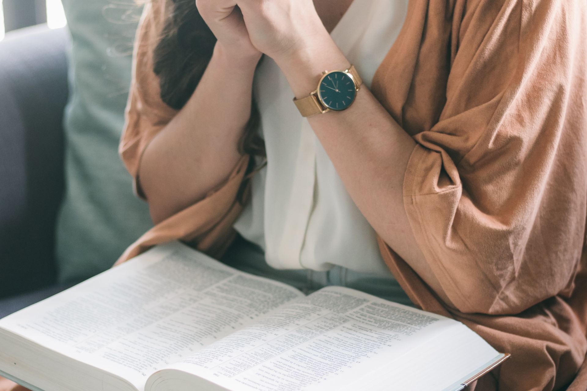 woman in brown robe sitting on black leather couch