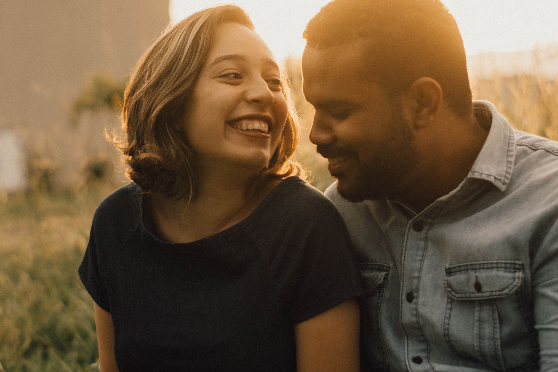 woman wearing black shirt sitting near man outside during sunrise