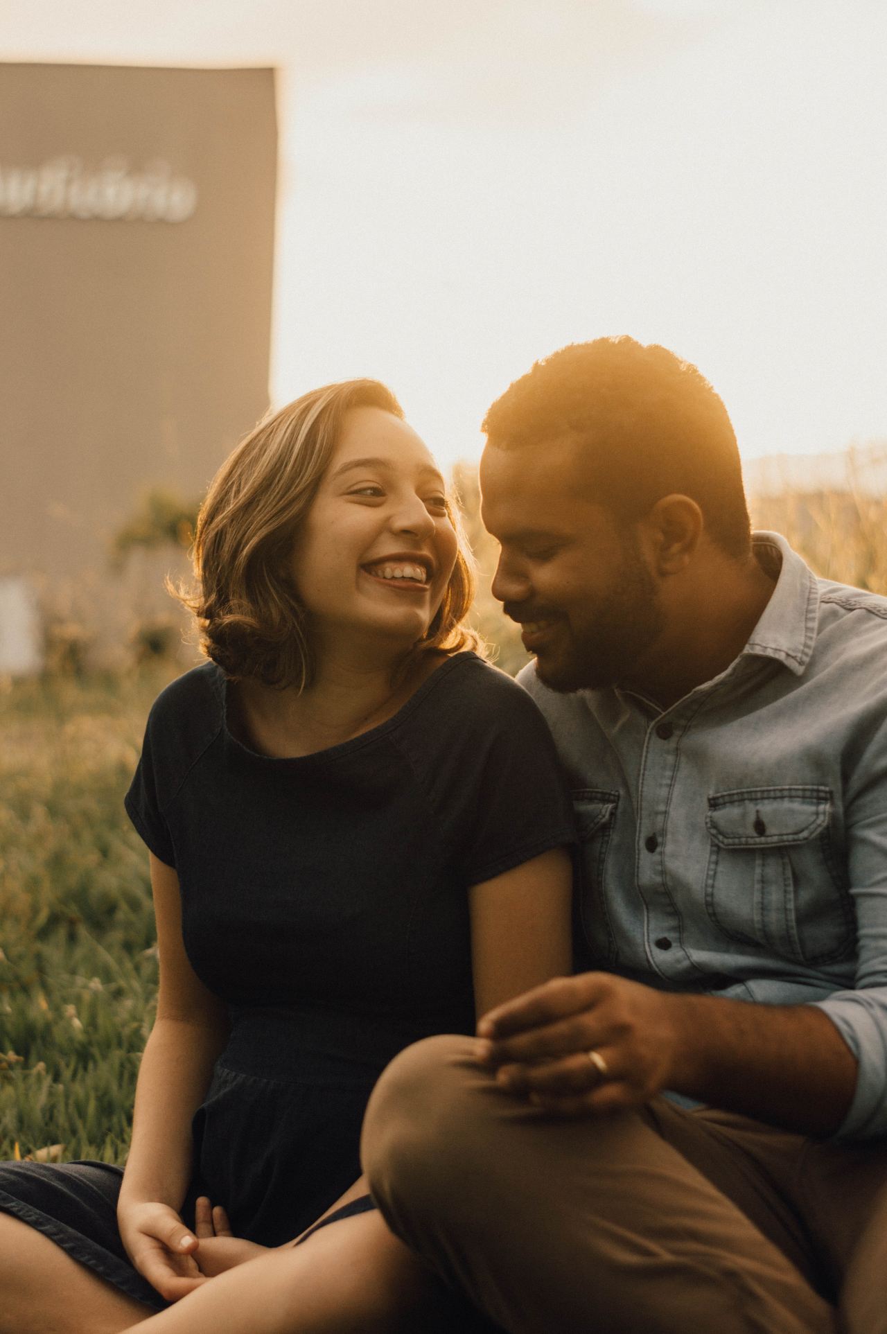 woman wearing black shirt sitting near man outside during sunrise