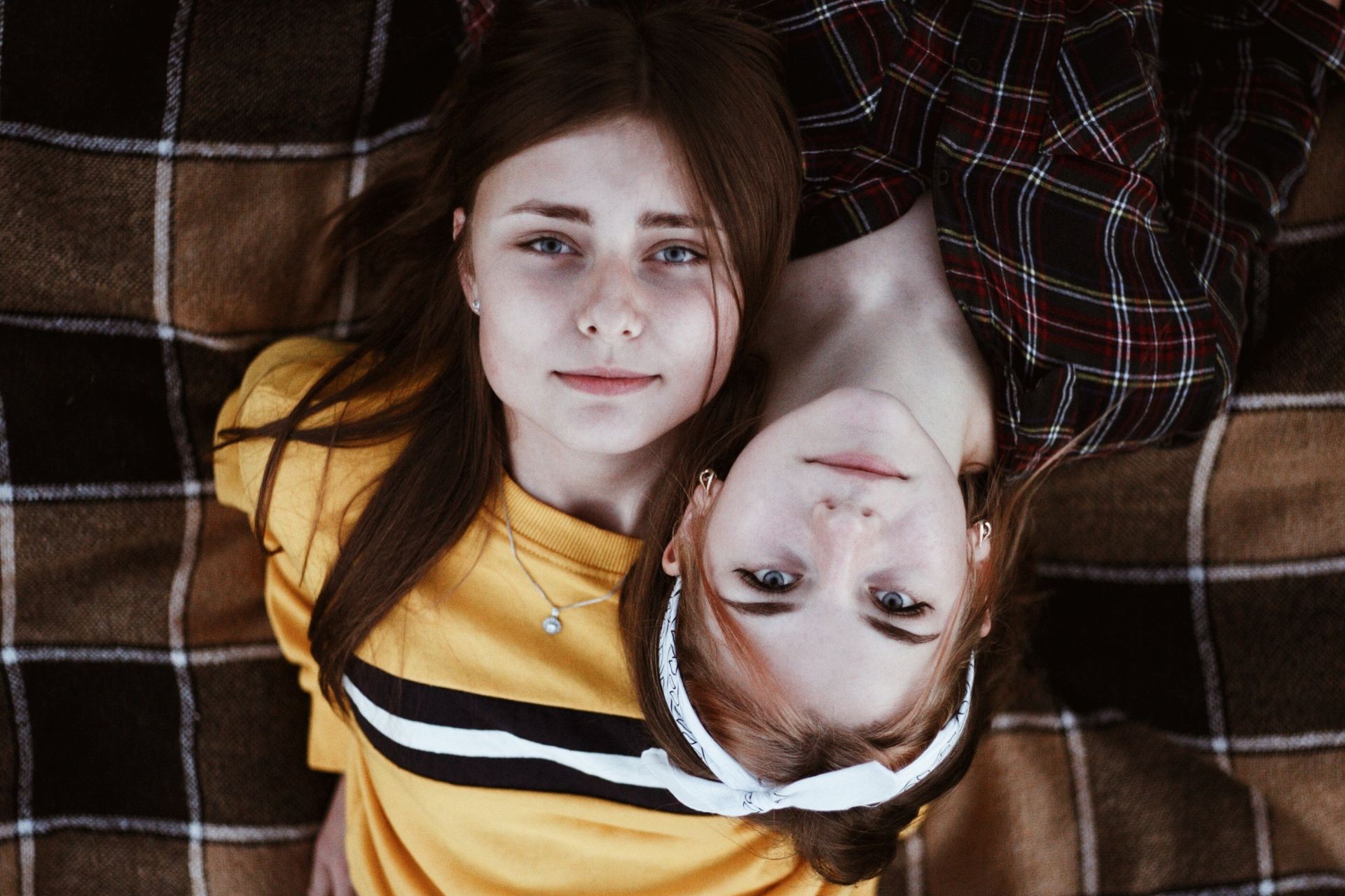 man in yellow and black striped polo shirt lying on brown sofa