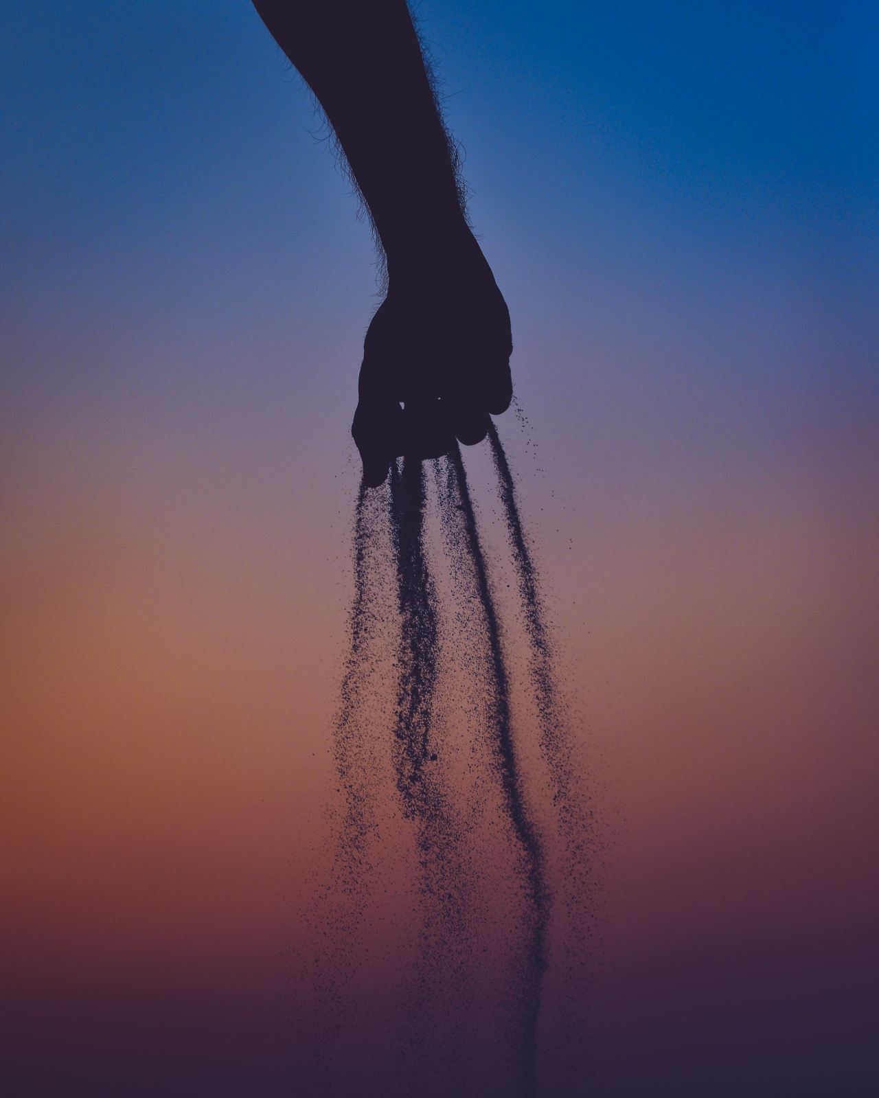 person dropping sand from his hands