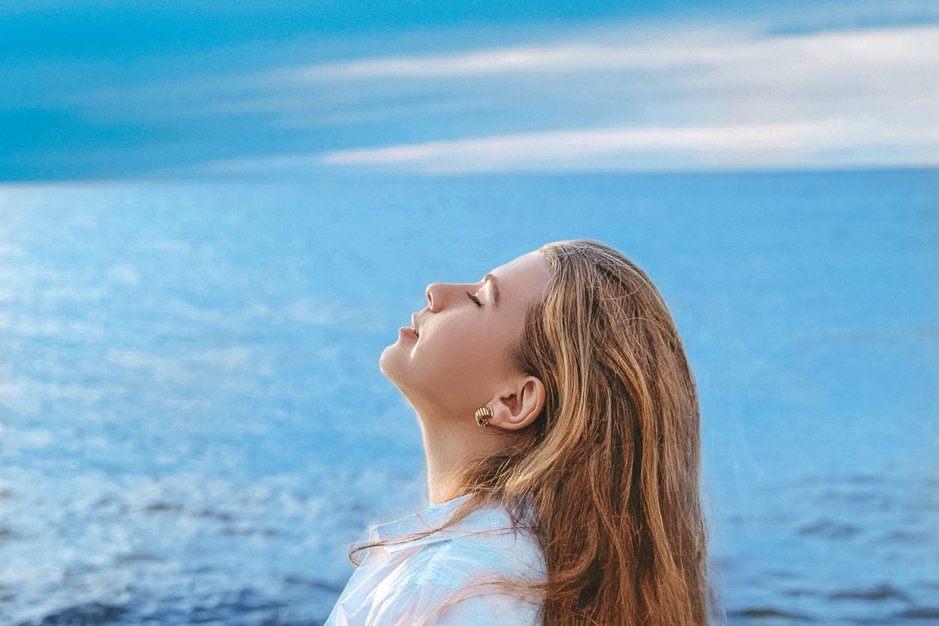 woman in white shirt standing near sea during daytime