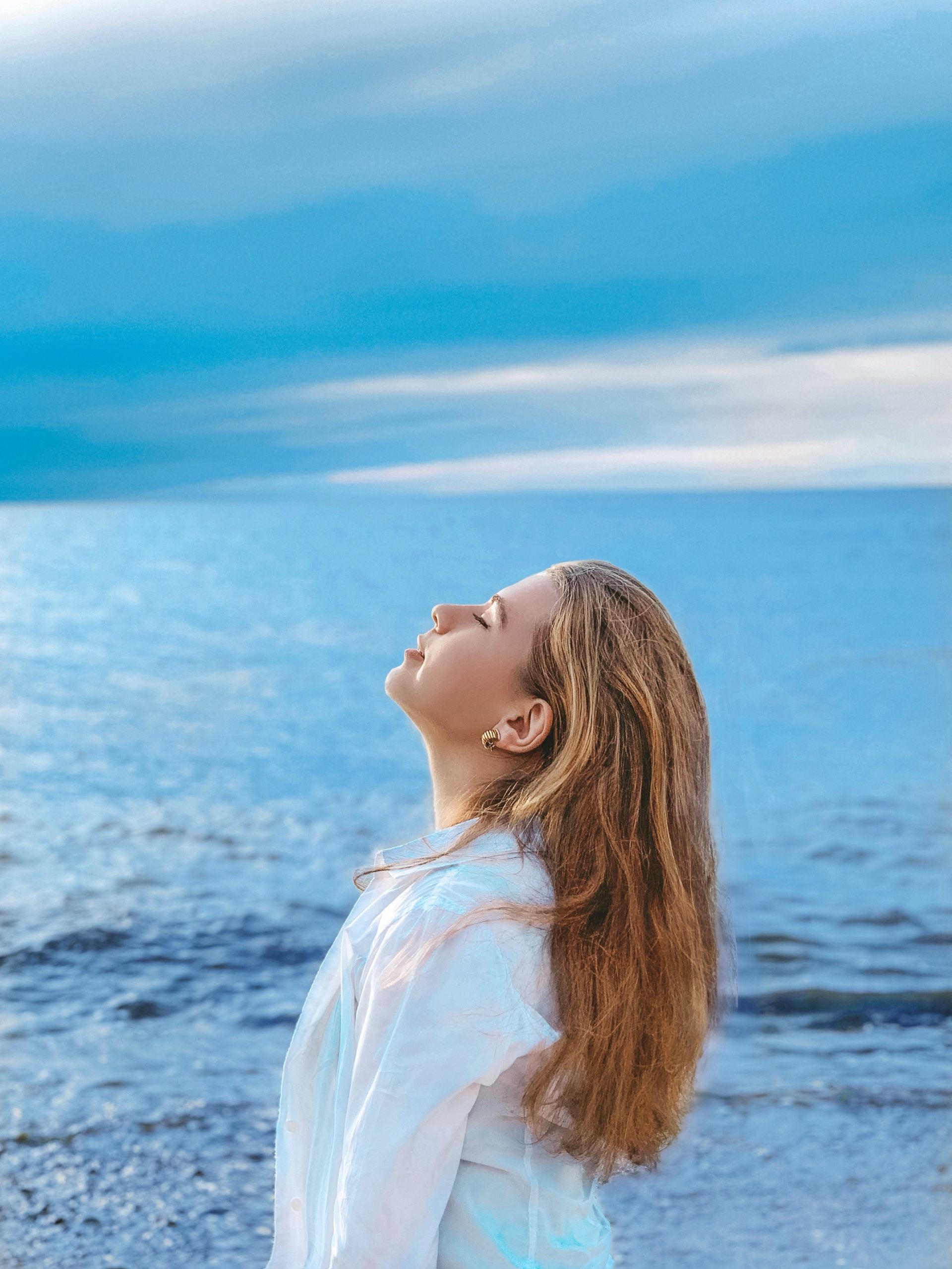 woman in white shirt standing near sea during daytime