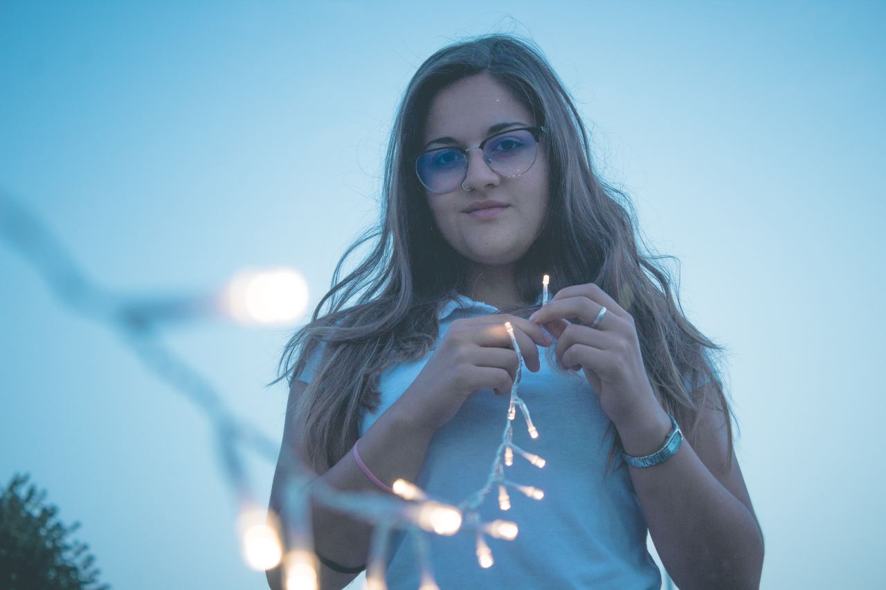 woman holding string lights