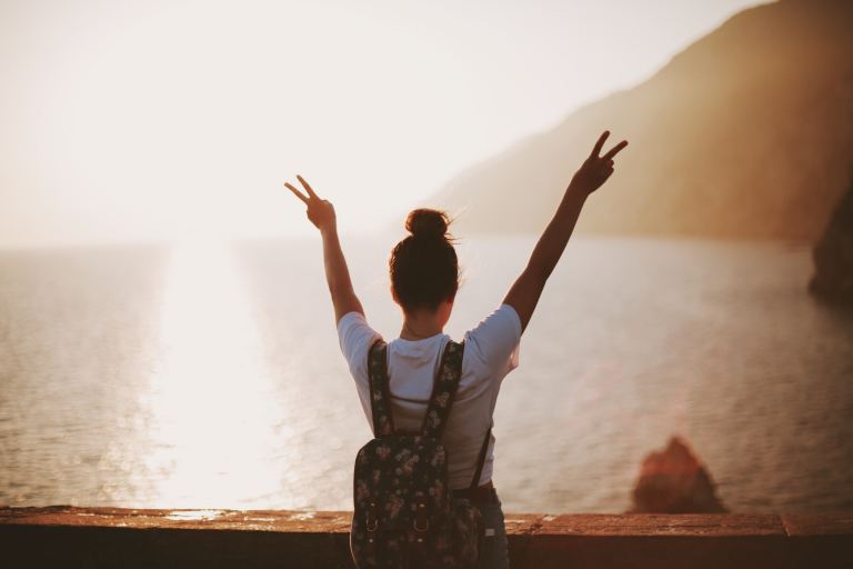 woman standing near seashore doing peace sign