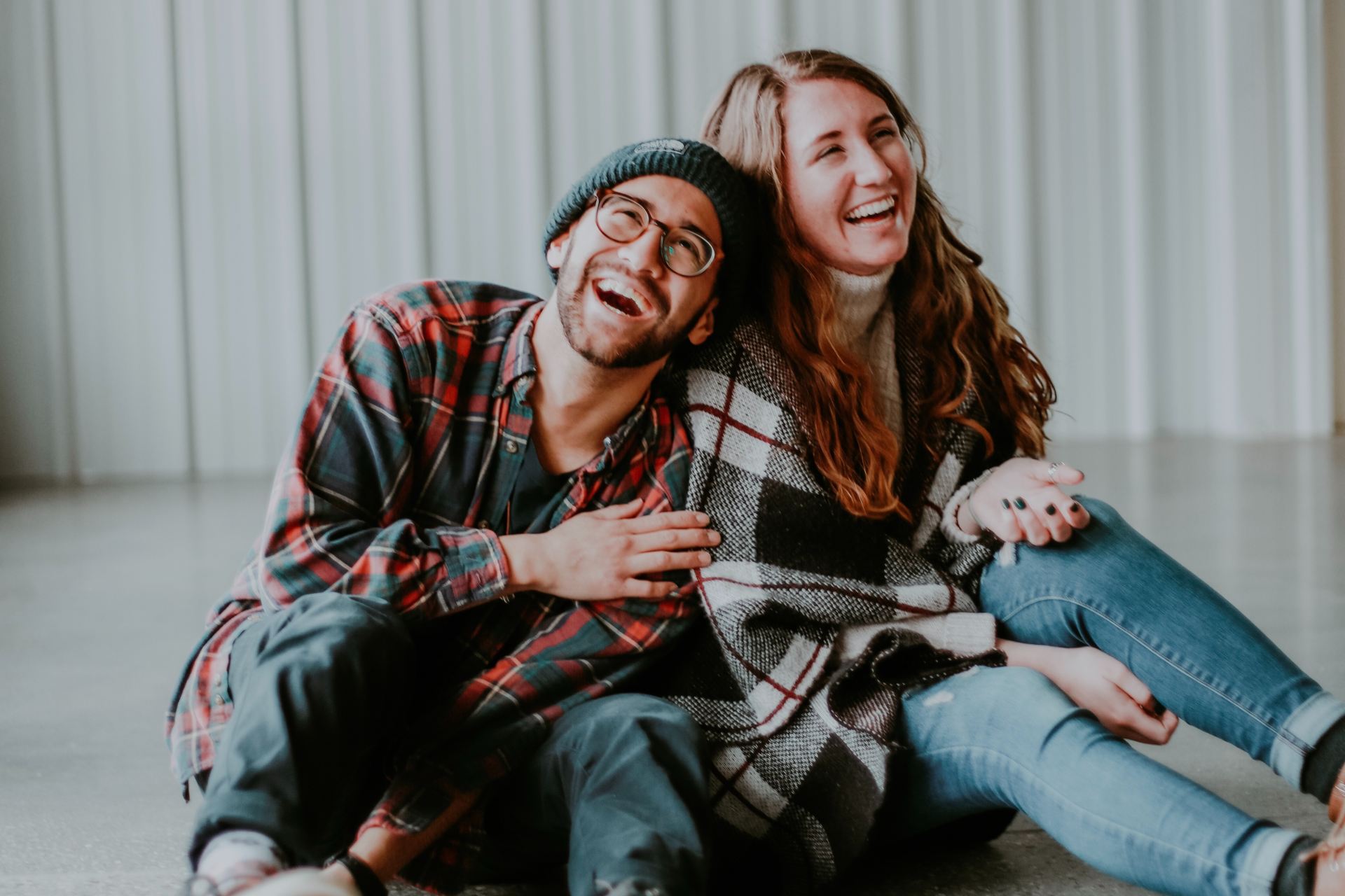 smiling woman and man sitting on floor