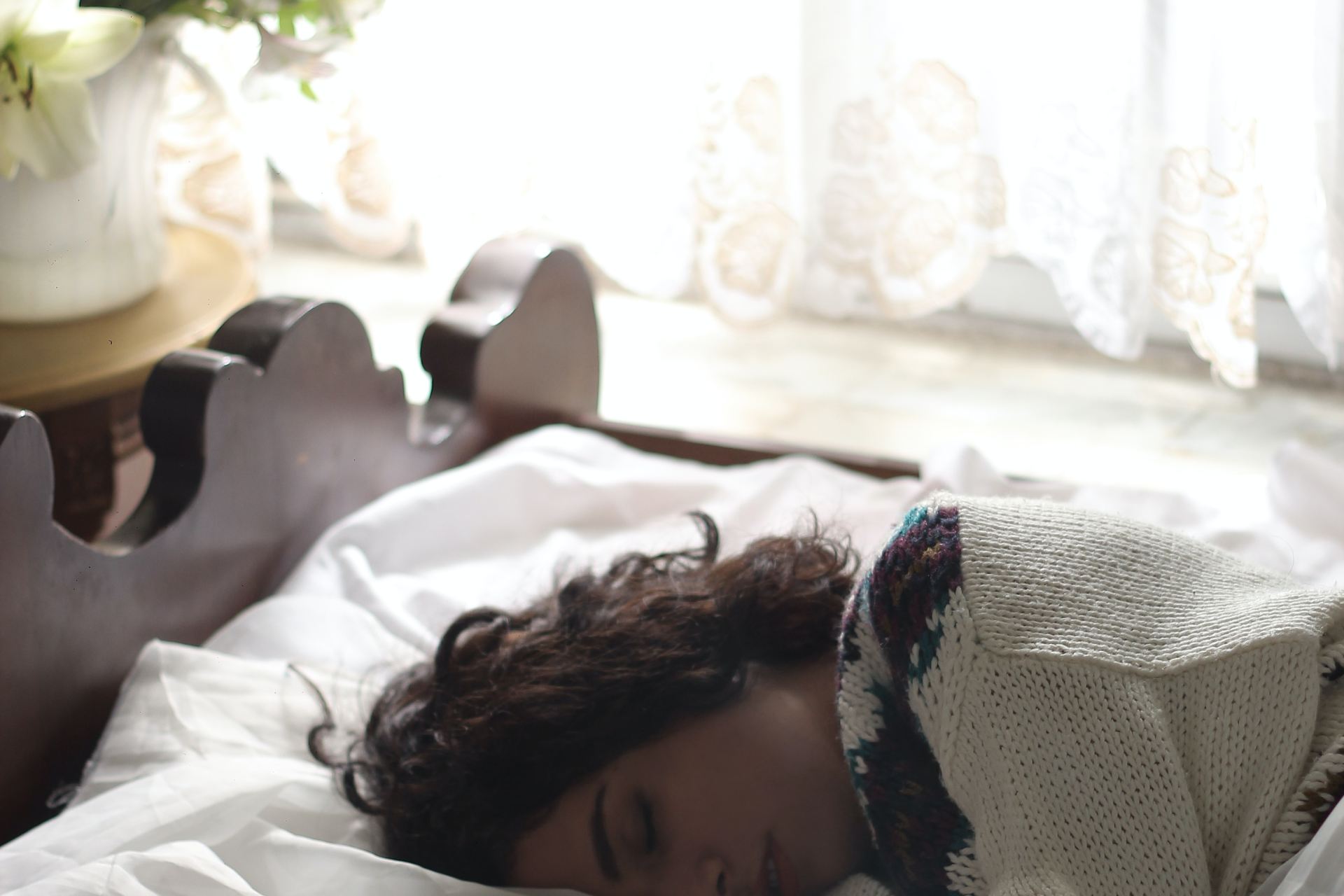 woman sleeping on bed beside book