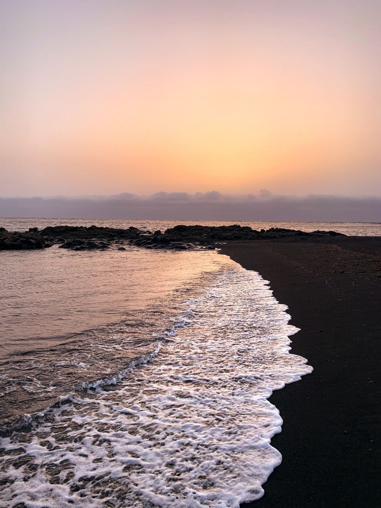 ocean waves crashing on shore during sunset