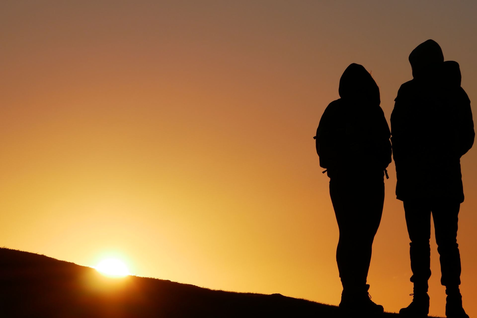 silhouette of people on top of hill during sunset