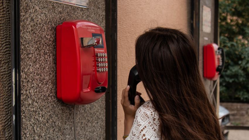 woman using payphone