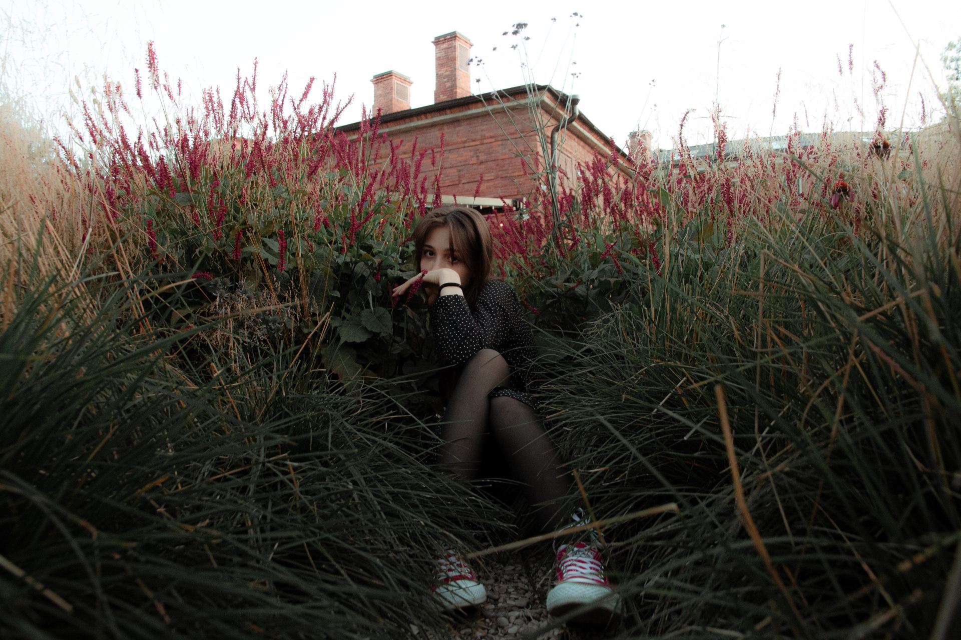 woman in black and white stripe shirt sitting on green grass during daytime