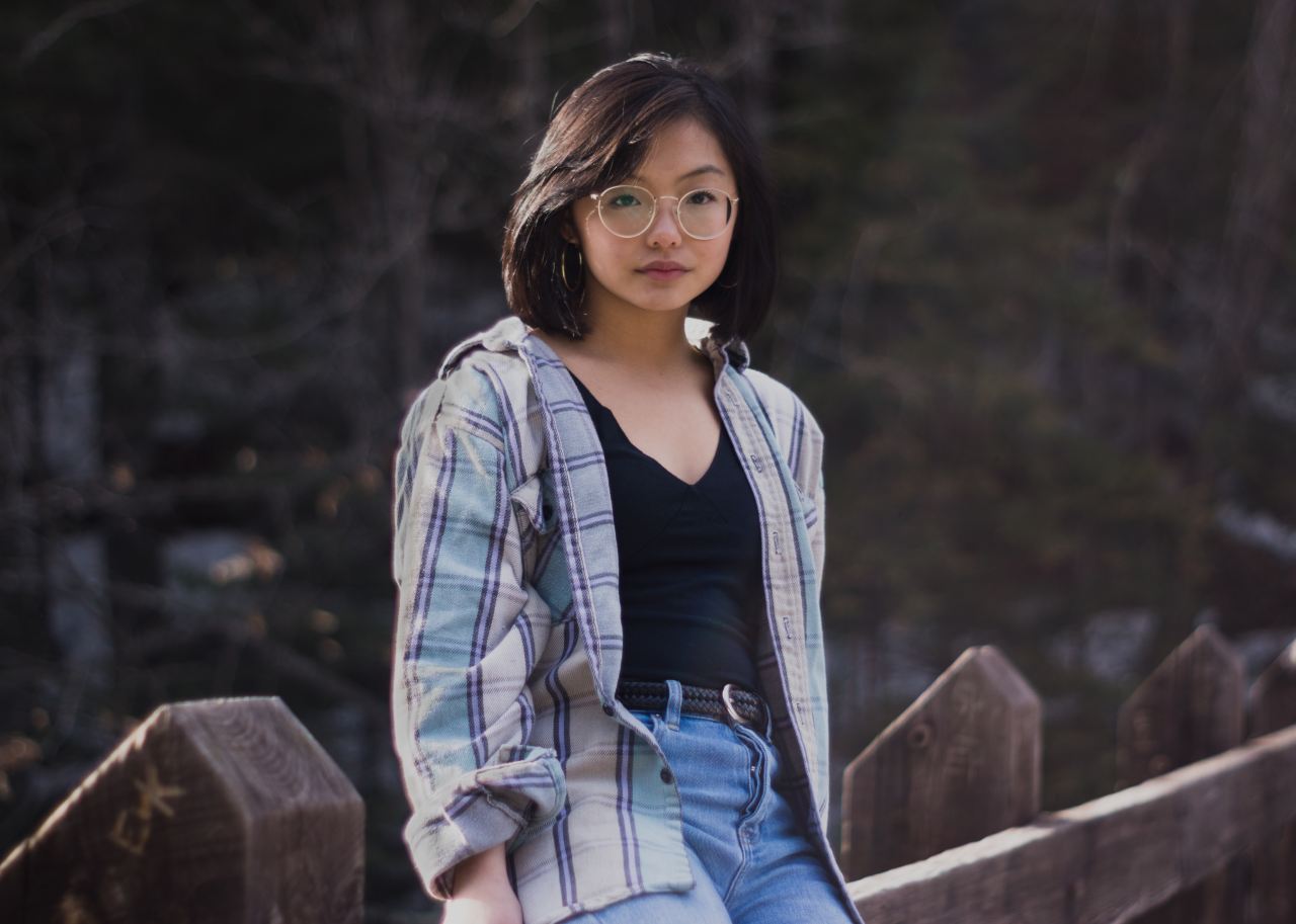 woman leaning against wooden fence