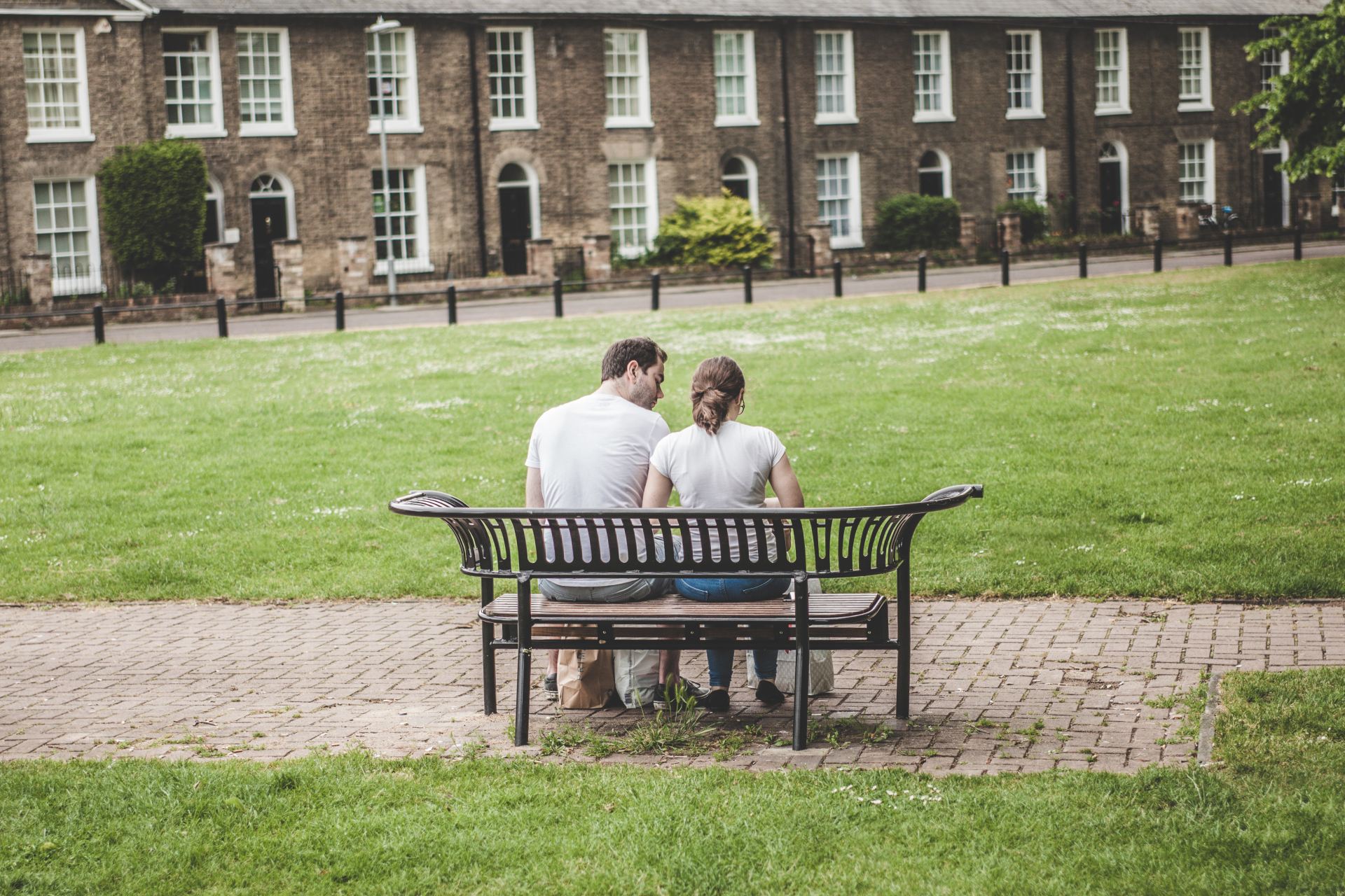 man and woman sitting on bench