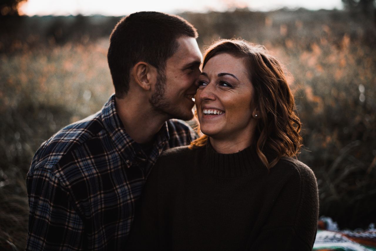 man in blue and white plaid sport shirt beside woman in black crew-neck sweater