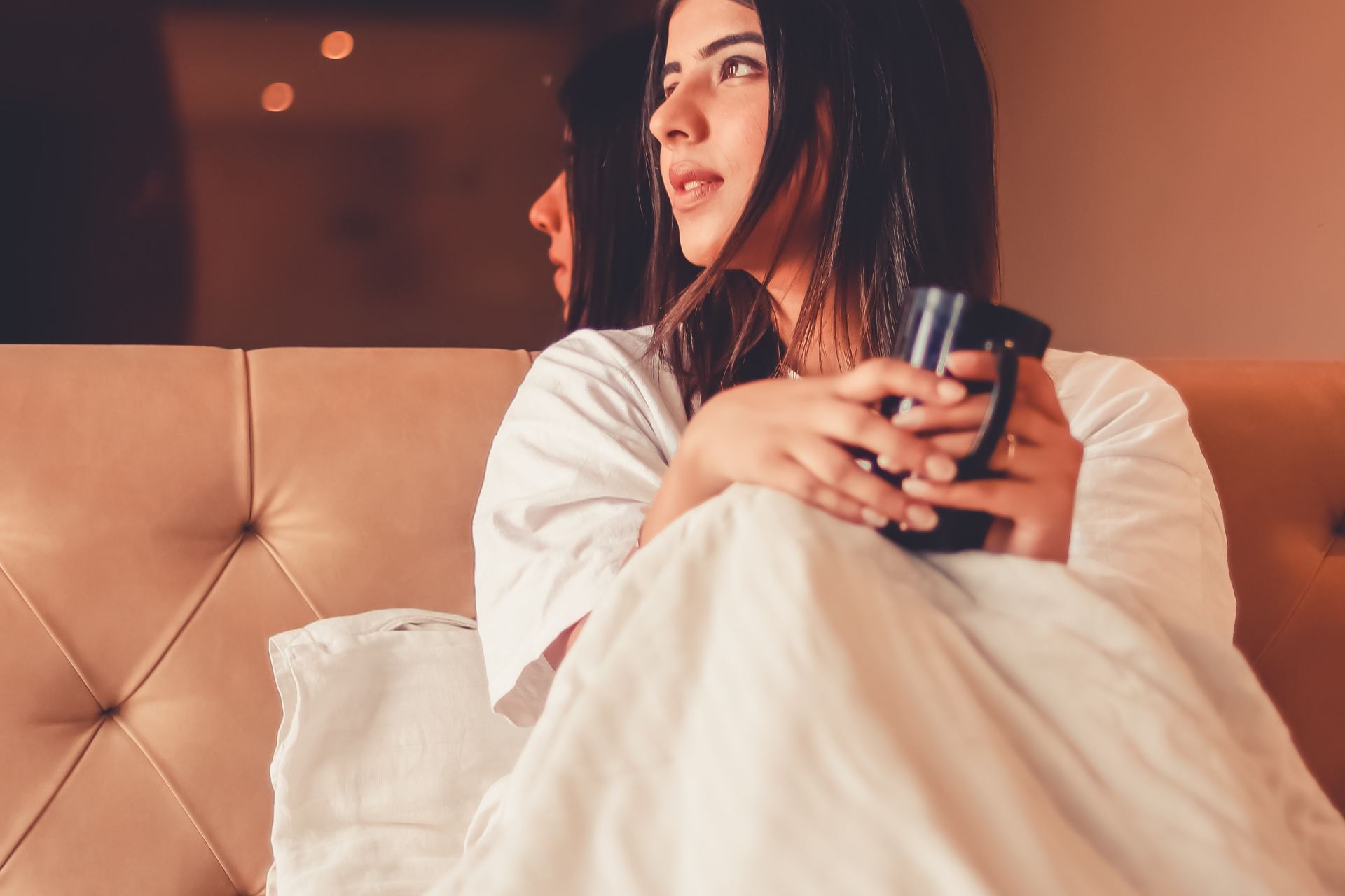 woman in white robe sitting on couch