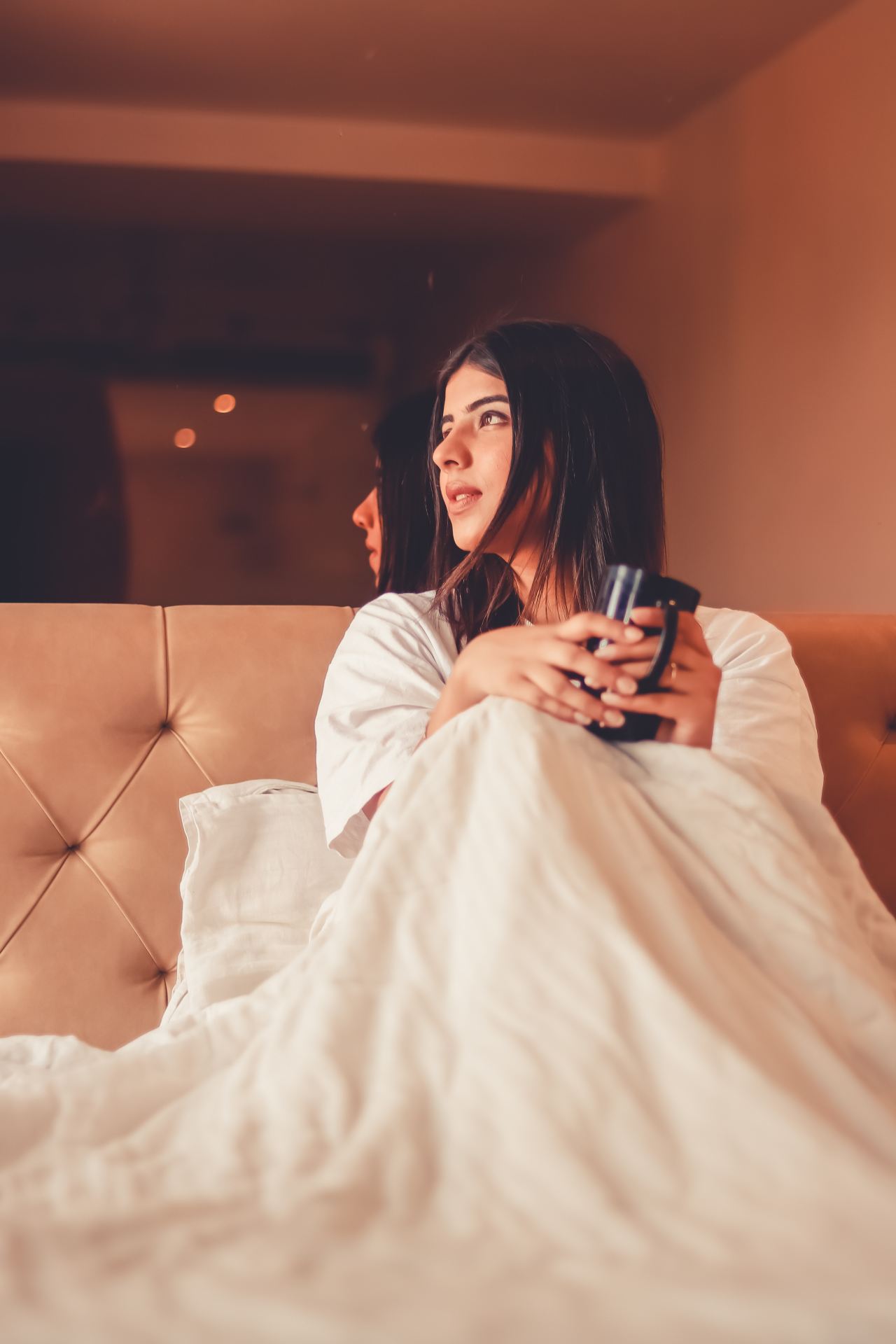 woman in white robe sitting on couch