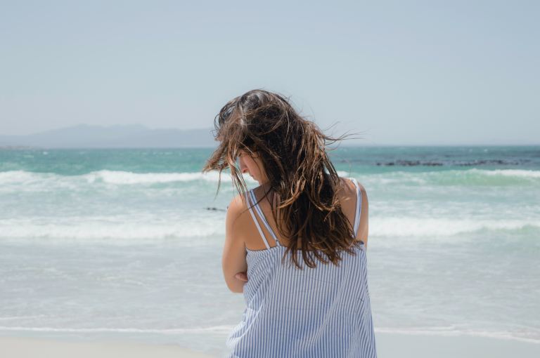 woman standing on beach during daytime