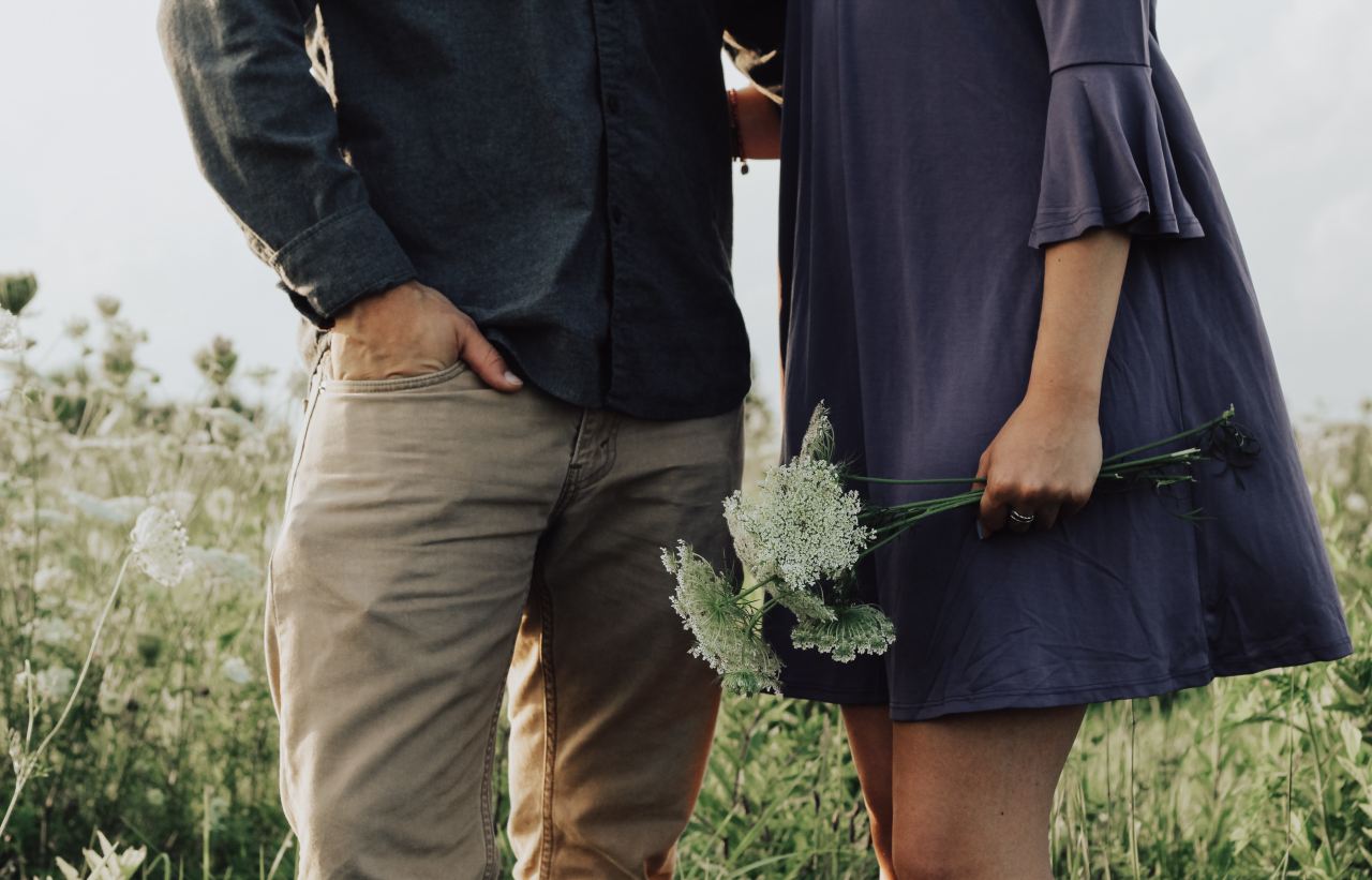 man and woman standing on white flower field at daytime