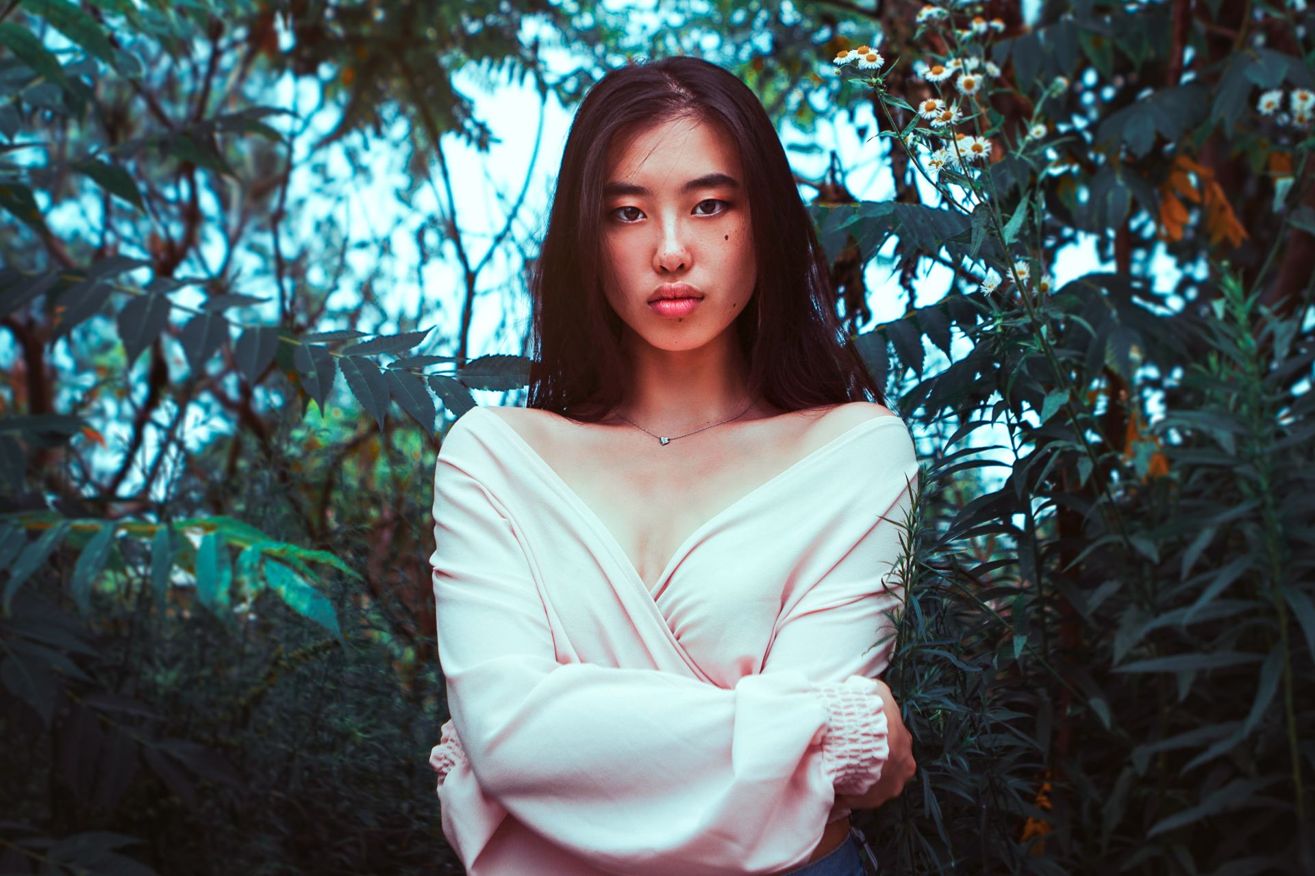 woman in white long sleeve shirt standing near green leaf tree