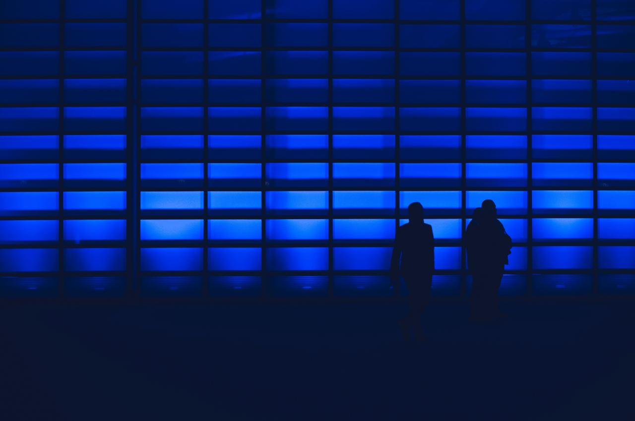 silhouette photo of two person standing near wall