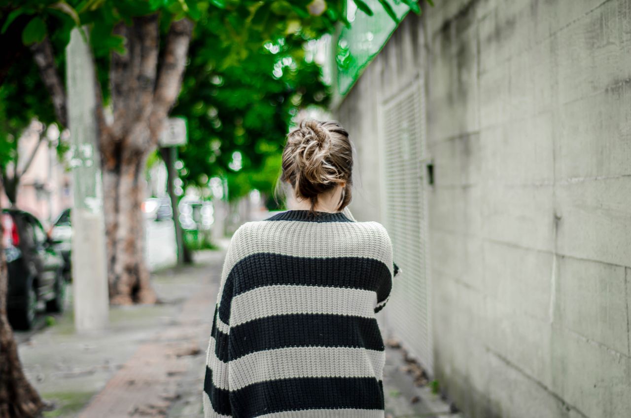 selective focus photography of woman walking on sideroad