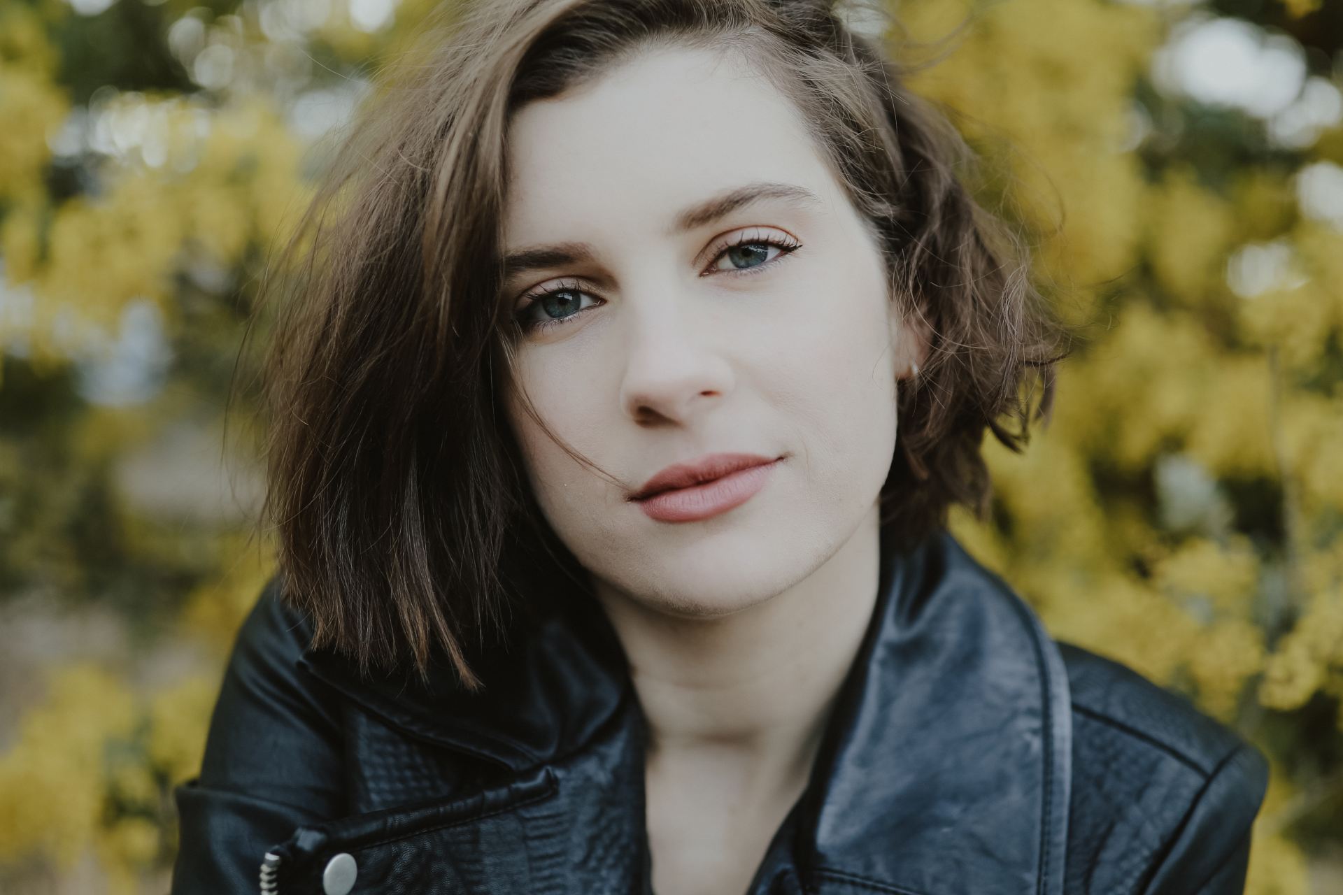 selective focus photography of woman wearing black leather zip-up jacket