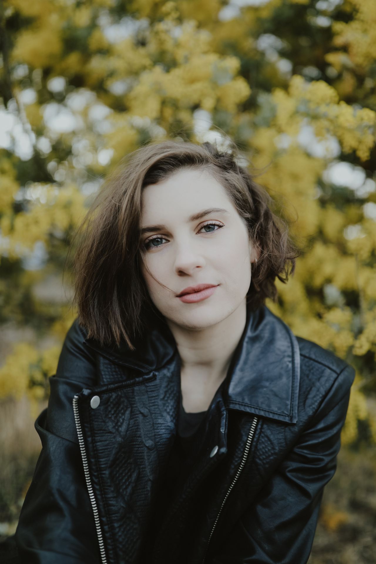 selective focus photography of woman wearing black leather zip-up jacket