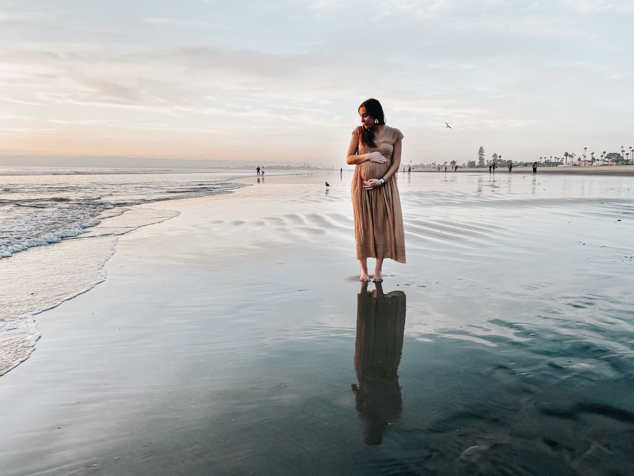 woman in brown dress standing on beach during daytime