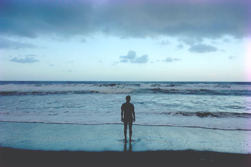 silhouette photography of man standing on seashore