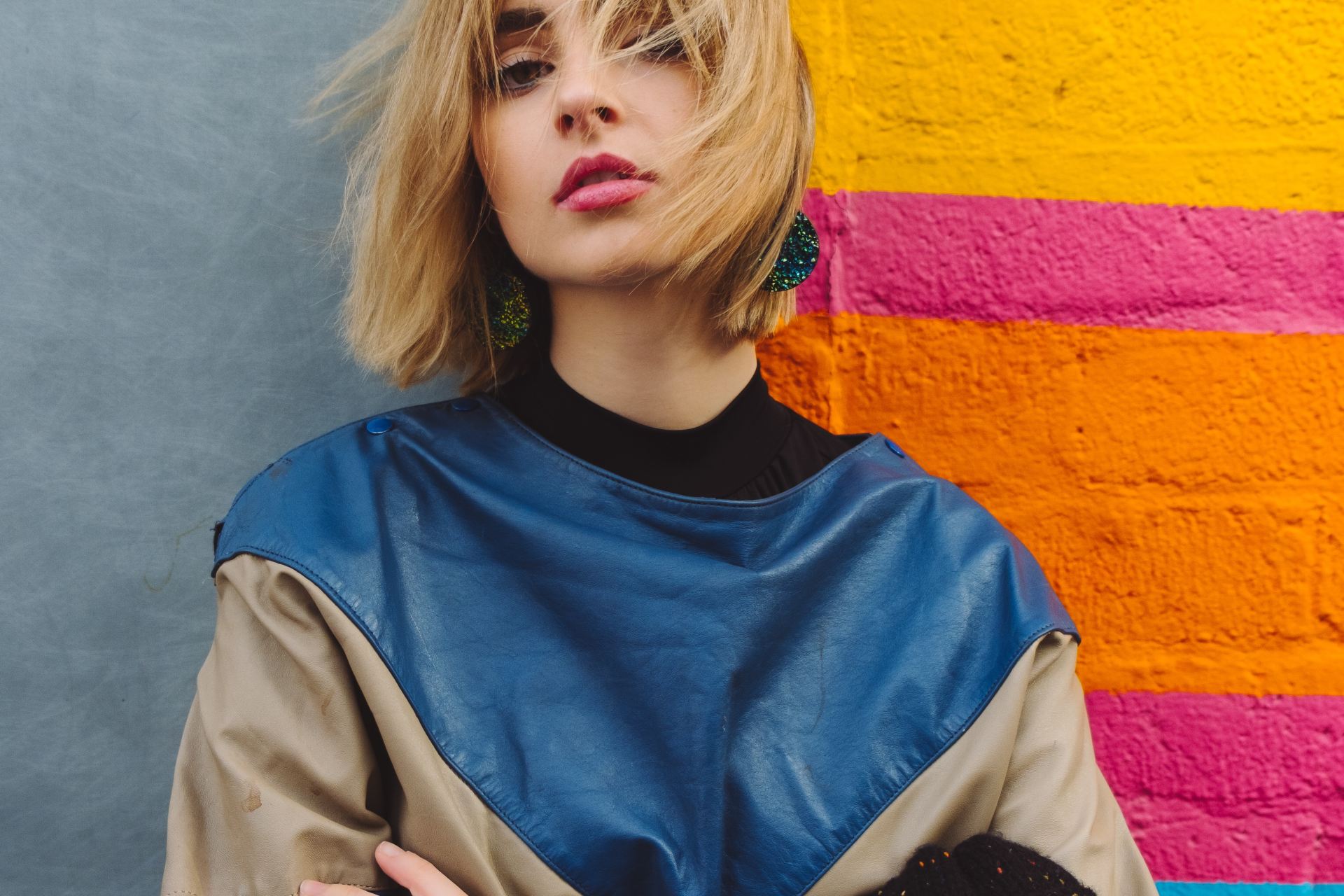 woman standing near pink, yellow, and blue painted wall