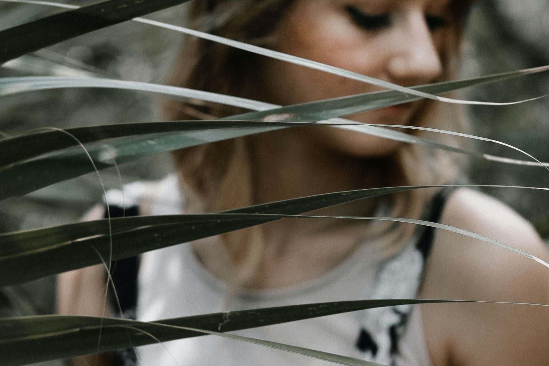 woman standing near linear leafed plant