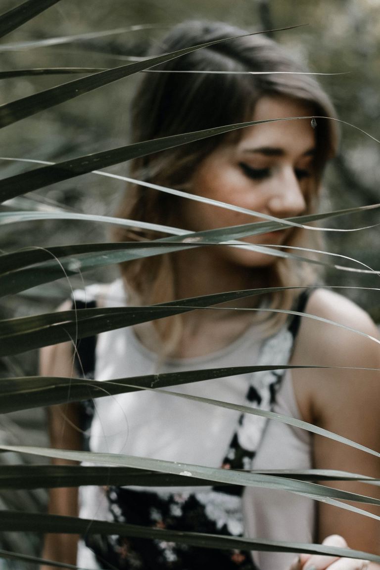 woman standing near linear leafed plant