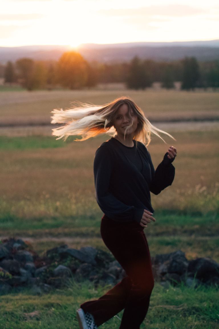 woman in black sweater and maroon pants outfit at field during daytime