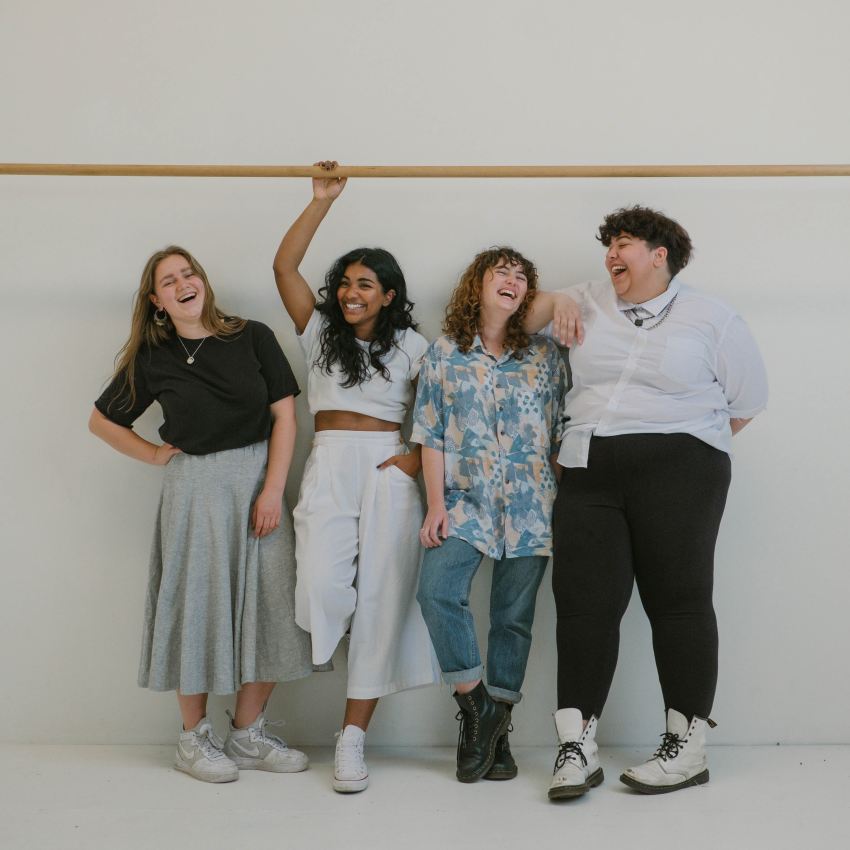 four person standing beside wall