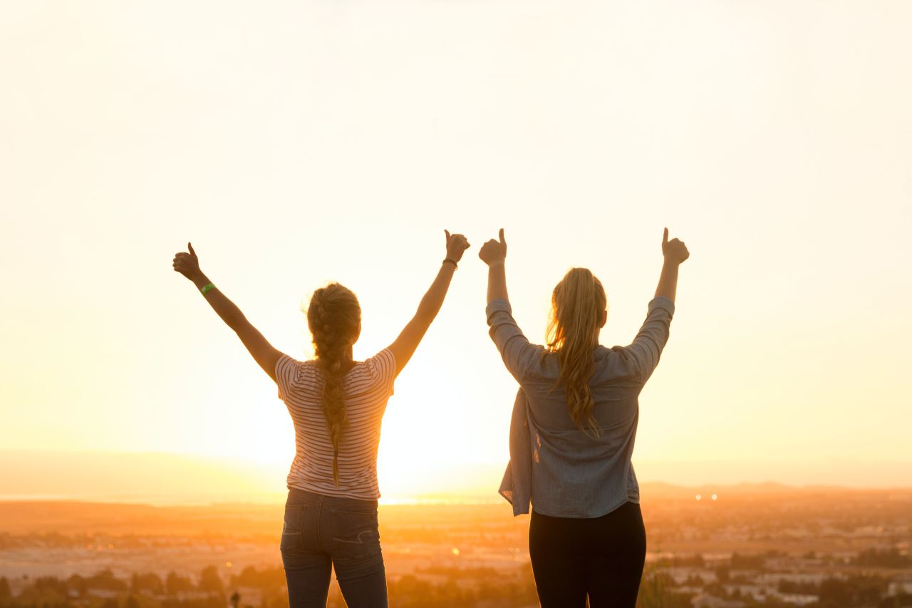 two woman standing near field