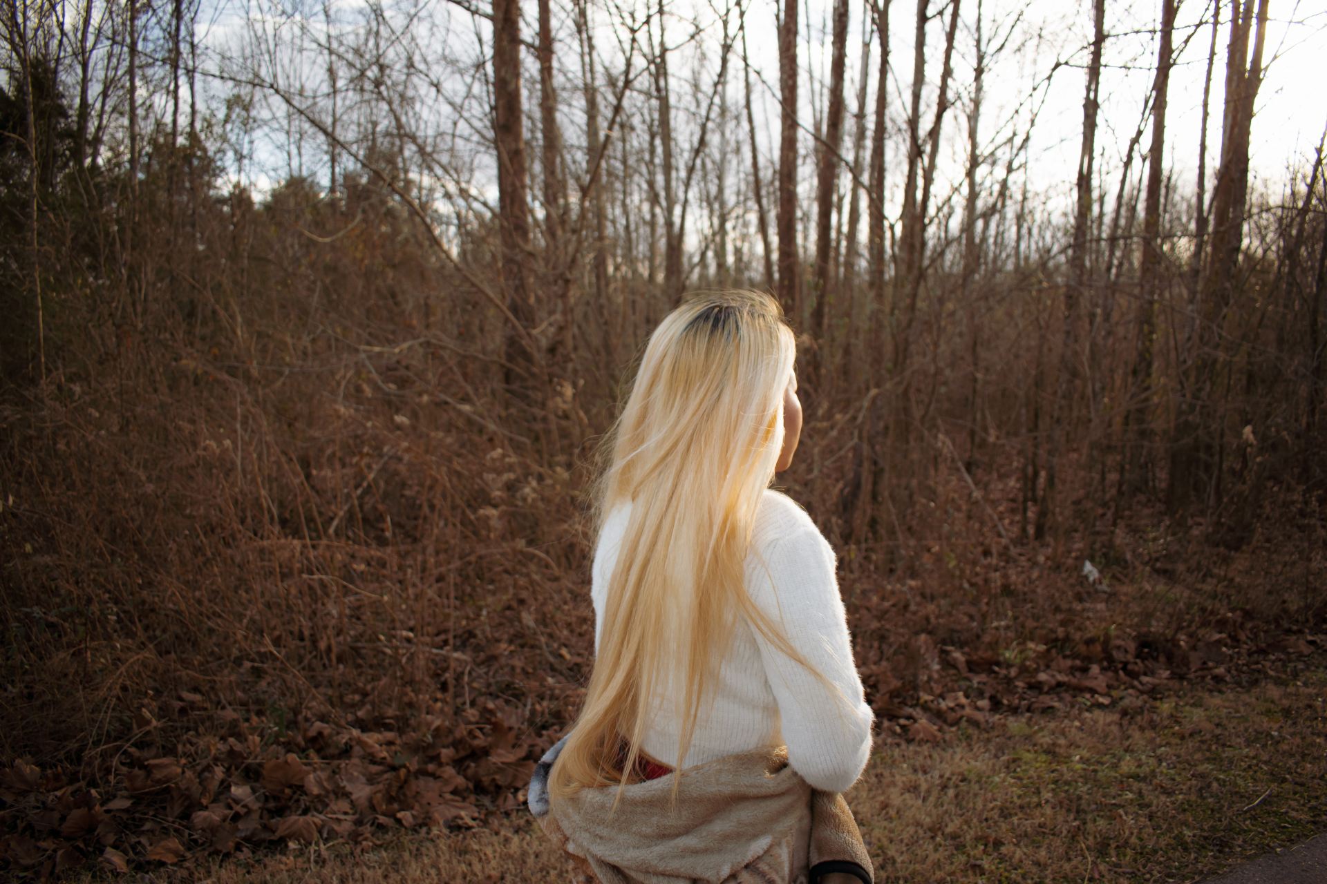 woman in white long sleeve shirt standing on brown grass field during daytime